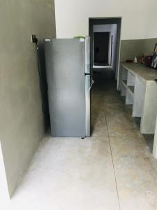 een keuken met een koelkast in het midden van een kamer bij Coconut House in Panadura