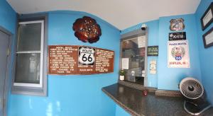 a restaurant with a sign on a blue wall at Plaza Motel in Joplin +21 photos