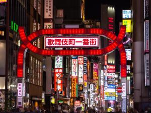 una gran señal roja en medio de una ciudad por la noche en APA Hotel Higashi Shinjuku Kabukicho Tower en Tokio