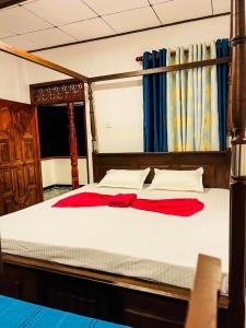 Una cama con un vestido rojo encima. en Shanika Guest & Villa, en Mirissa
