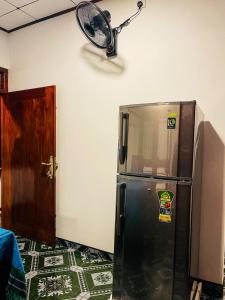 um frigorífico num quarto com uma ventoinha na parede em Shanika Guest & Villa em Mirissa