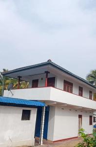 une maison blanche avec un toit bleu dans l'établissement Shanika Guest & Villa, à Mirissa