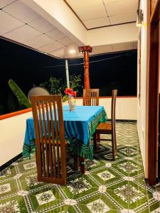 a table with chairs and a blue table cloth on a floor at Shanika Guest & Villa in Mirissa