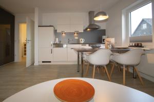 cocina con mesa y sillas blancas en Haus Schössler, Whg 1, en Hörnum