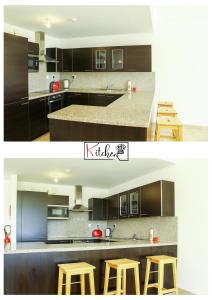 a kitchen with brown cabinets and three stools in it at Sifah-Wateera Property Management Marina Apartments in As Sīfah