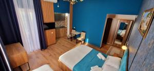 una camera blu con un letto e una scrivania di Balu a Kobuleti