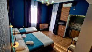 una camera d'albergo con due letti e una parete blu di Balu a Kobuleti