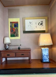 uma sala de estar com uma cómoda de madeira e um candeeiro em Homey Inn Enya em Yufu