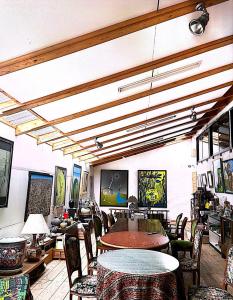 a restaurant with tables and chairs and paintings on the walls at Homey Inn Enya in Yufu