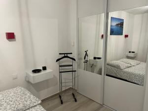 Habitación blanca con 2 camas y espejo. en Un havre de paix au cœur de Mougins, en Mougins