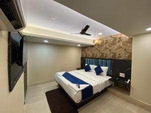 孟買的住宿－Hotel 97 Inn- Andheri Versova，一间卧室配有一张带蓝色和白色枕头的床