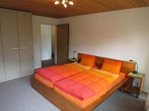 1 dormitorio con cama de madera y manta naranja en Villa Franca E06, en Arosa