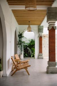 een veranda met twee stoelen en een potplant bij Villa Batu Putih Seminyak in Seminyak