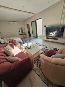 a living room with two couches and a tv at Sky2030Group in Dammam