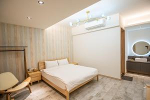a bedroom with a bed and a chair and a mirror at #66 Homestay in Magong +23 photos