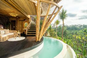 een resort met een zwembad en een huis bij Bambootel Sawah View in Ubud