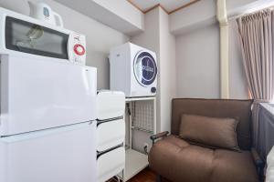 a small room with a chair and a refrigerator at JR高田馬場駅早稲田大学口徒歩5分 Hostel 302 in Tokyo