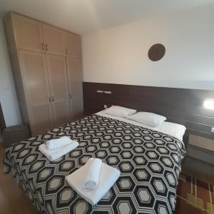 a bedroom with a bed with white towels on it at VIP Apartments Belvedere with terrace K105 in Bansko