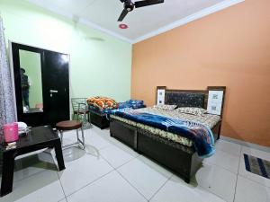 a bedroom with two beds and a table in it at Gopal Hotel and Palace in Jhunjhunūn