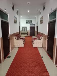 a room with three couches and a red carpet at Hotel Mallard Rainbow in Bharatpur