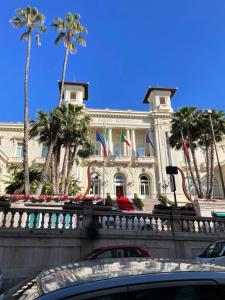 un bâtiment avec des palmiers en face de celui-ci dans l'établissement Civico 10, à Sanremo