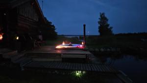 a lit up fire pit on a deck at night at Elimaa-Lepiku in Hõbesalu