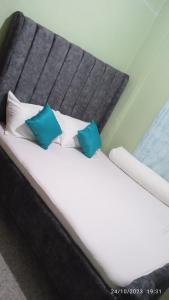 a bed with two blue pillows on it at Joyful homes Air Bnb in Naivasha