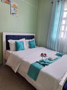 a bedroom with two beds with blue and white pillows at Joyful homes Air Bnb in Naivasha