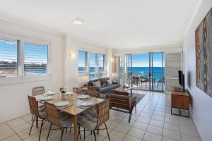 a living room with a table and chairs and a couch at Pandanus Court in Caloundra