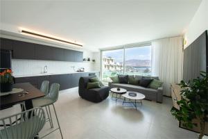 a kitchen and living room with a couch and a table at Seaside Haven-City Center Amazing Pool and Sea view in Eilat