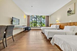 una fila di letti in una camera d'albergo di Siloso Beach Resort - Sentosa a Singapore