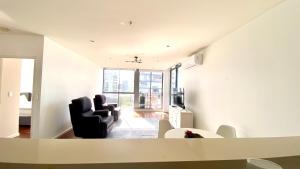 Solaire Apartments في غولد كوست: غرفة معيشة مع كرسيين وطاولة