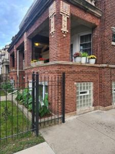 um edifício de tijolos com vasos de plantas numa janela em Relaxing Entire Roseland Neighborhood Apartment Unit em Chicago