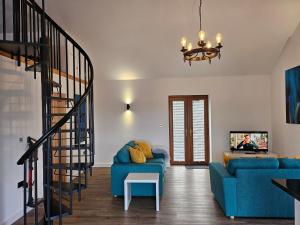 a living room with a blue couch and a staircase at Brooke View Barns No 1 in Norwich