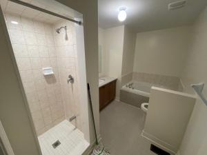 a bathroom with a shower and a toilet and a sink at Comfort King in Oshawa