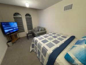 1 dormitorio con 1 cama y TV de pantalla plana en Comfort King, en Oshawa