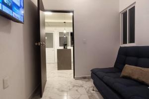 een woonkamer met een bank en een televisie en een hal bij Departamento Excelente ubicación Depto C in Orizaba