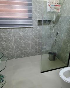 een badkamer met een douche en een emmer bij Elegantly furnished studio in Asokoro in Aso