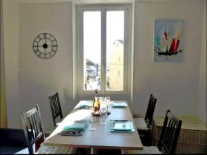 a dining room table with chairs and a large window at COTE PORT T2 vue port centre ville Bandol in Bandol