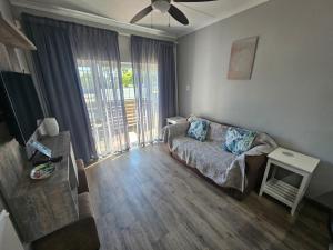 a living room with a couch and a large window at Secure Private Flatlet in Newton Park in Port Elizabeth