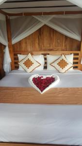 Una cama con una caja en forma de corazón. en Ti Amo Bali en Jatiluwih