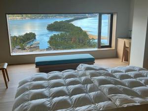 a large bed in a room with a large window at Genmyoan in Miyazu