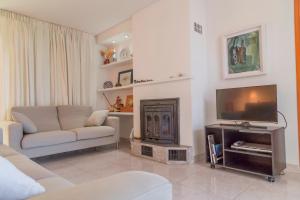 a living room with a couch and a television at Can Francesc Wifi, BBQ, garden, 200m from the beach for 8 in Port d'Alcudia