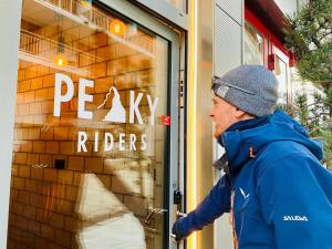 a man standing in front of a store window at Peaky Riders Self Check-in Hotel in Zermatt