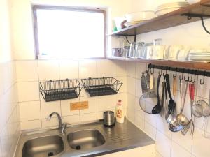 a kitchen with a sink and a window and utensils at Holiday Home Olivia House in Dobra Voda