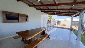 a living room with a bench and a tv on the wall at Casa com Piscina (Somente para 4 Hóspedes). in Sinop