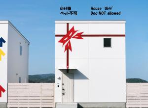 un edificio blanco con flechas rojas. en 淡路島貸別荘リアンみなと, en Minamiawaji