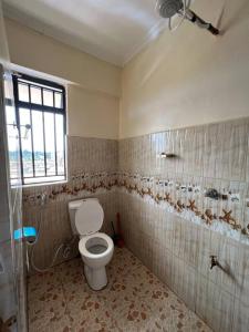 a bathroom with a toilet and a window at Luxe suite (1bedroom) in Nambale