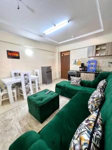 a living room with a green couch and a table at Luxe suite (1bedroom) in Nambale
