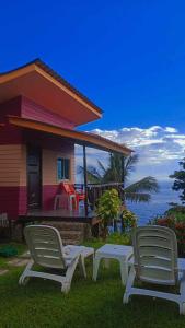 a house with two lawn chairs and a house at Cliff View Bungalows in Ko Chang